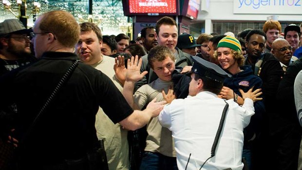 Shoppers attempt to push their way through security staff moments after the doors open outside of Best Buy at the Mall of America.
