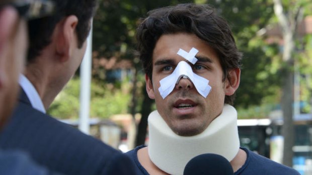 The damage done: Thomas Drouet speaks to media in Madrid on Monday, with a bandaged nose and wearing a neck brace. The Frenchman, Bernard Tomic's training partner, alleges John Tomic headbutted him.
