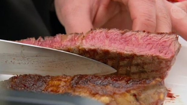 George cuts into Ben's steak to see how well it's cooked.