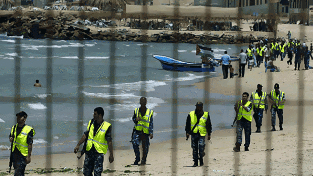 Palestinian members of the Hamas police force patrol the beach in preparation for the arrival of the small flotilla.