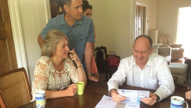 Gordon Park couple Amy Ward and Todd Winks go over their power bills with Premier Lord Mayor Campbell Newman on Sunday morning.
