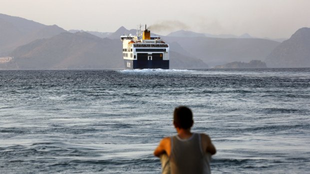 A Bangladeshi migrant, pending temporary documentation, watches from the port of Kos, Greece, a ferry bound for the port of Piraeus near Athens on Monday.