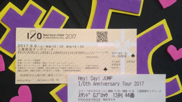 The orange card ticket told the gate letter, while the white paper ticket gave the final seat number moments before the show.