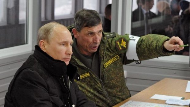 Russian President Vladimir Putin, listens to General Ivan Buvaltsev, right, as they observe a military exercise near St Petersburg, Russia.  