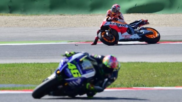 Yamaha rider Valentino Rossi speeds away as Honda's Marc Marquez takes a tumble in the San Marino MotoGP on Sunday.