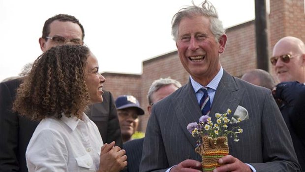 All smiles ... Britain's Prince Charles laughs after he was given flowers by Pertula George.