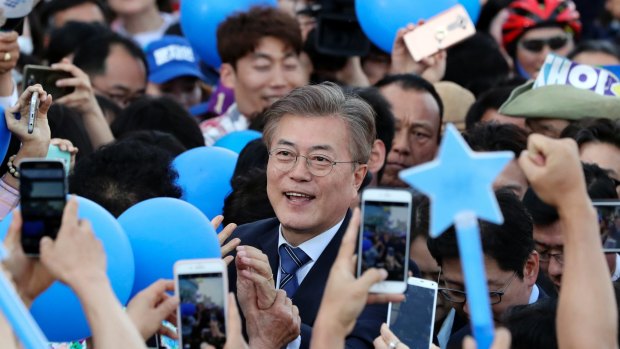 South Korean presidential candidate Moon Jae-in of the Democratic Party is surrounded by his supporters upon his arrival for an election campaign in Gwangju, South Korea.