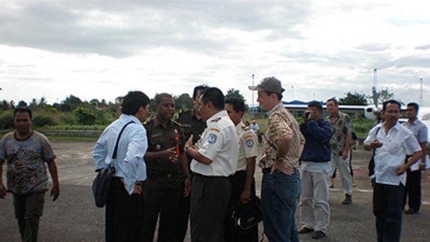 Not so fast ... immigration officials bicker with Yafeth Bonai, second from left, on the runway at Merauke airport yesterday.