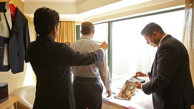 Suits you &#8230; Martin Raja, left, and Harry Menon from Raja Fashions of Hong Kong take the measurements of a Sydney client at the Pullman hotel near Hyde Park.