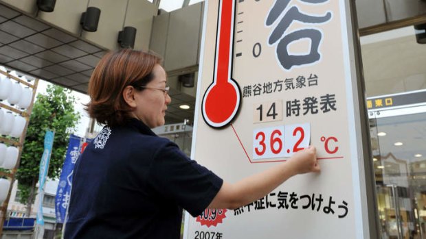 Hot days: A worker at a department store puts up the current temperature in Kumagaya, Saitama prefecture, on Sunday.