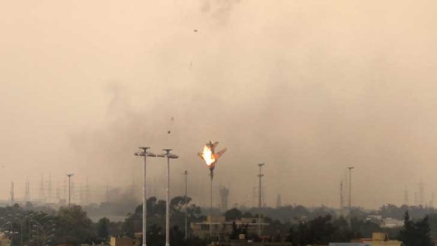 A fighter jet crashes to the ground in flames after reportedly being shot down over the rebel-held city of Benghazi yesterday.