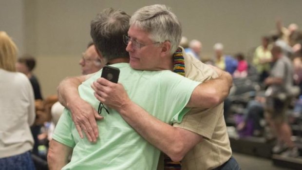 Gary Lyon and Bill Samford celebrate after the vote at the church's general assembly.