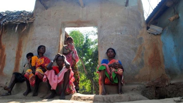 Santhal tribal women sit in a doorway of a home in a village where a woman was gang-raped at Subalpur, about 180 kilometres north of Kolkata, India.