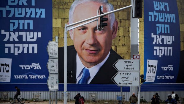 Last days ... Israelis walks past a picture of the Israeli Prime Minister Benjamin Netanyahu, whose party is facing stiff opposition in the polls two weeks out from the election.