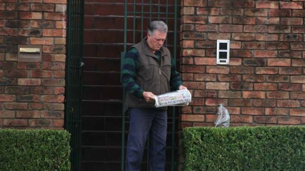 Bribery racket  ...  Paul Devine reads the Herald outside Doyabest, his house in Maroubra.