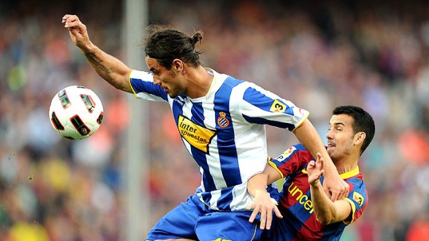 Espanyol's Pablo Osvaldo battles with Pedro Rodriguez of Barcelona.