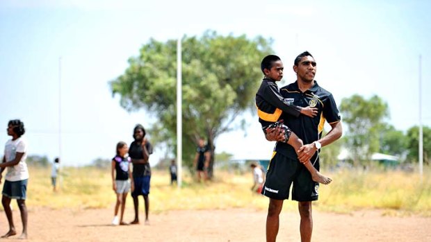 Home base: Gibson Turner with children from the Harts Range Community Primary School on a recent trip to the Northern Territory with Richmond teammates.