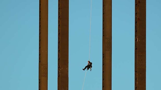 The "ex-military'" protester abseils down after staging his Harbour Bridge protest.