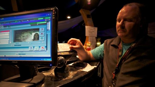 Forced to provide personal information: A security guard scans IDs as patrons enter a nightclub.