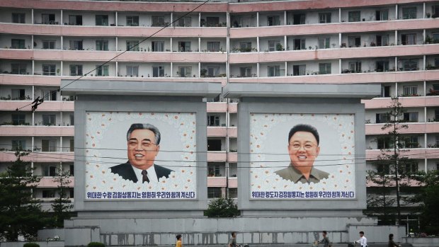 North Koreans are dwarfed by giant portraits of the late North Korean leaders Kim Il Sung and Kim Jong Il in Wonsan, North Korea. 