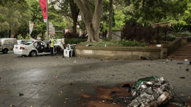 ‘‘Like a terrorist scene’’ ... the engine was torn from the taxi, which hit Hyde Park’s sandstone wall. Police cut the driver and pregnant passenger from the vehicle.