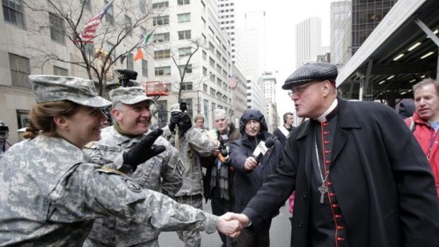 Cardinal Timothy Dolan greets National Guardsmen at the St Patrick's Day parade in New York. Parade organisers have announced they will allow the first gay group to march under its own banner.