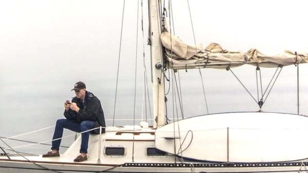 Glued to his phone: Eric J. Smith's photo of a man missing a rare sighting of a humpback whale up-close has gone viral.