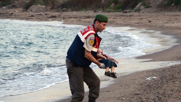 A Turkish paramilitary police officer carries the body of Aylan Kurdi in September.