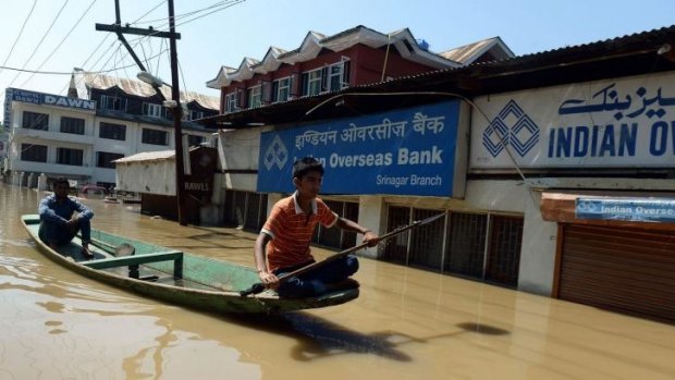 An Indian youth navigates through the flooded streets of Srinigar.
