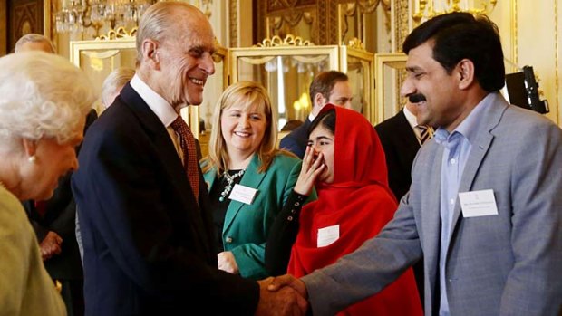 Reception: Malala Yousafzai, with her father, reacts to Prince Philip's joke after meeting the Queen.