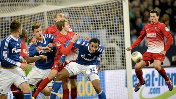 Freiburg's Nicolas Hoefler, right, scores an goal after Schalke's players missed a corner.