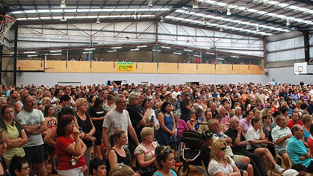 A crowd of hundreds gathers for an emergency meeting at the Armadale Arena evacuation centre.