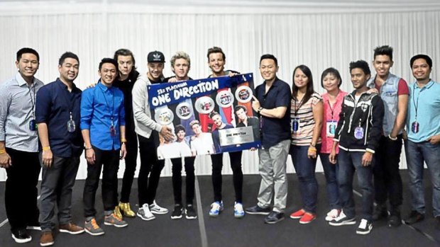 One Direction's Liam Payne covers the face of on-leave band member Zayn Malik at a photo call during the band's Asian tour.