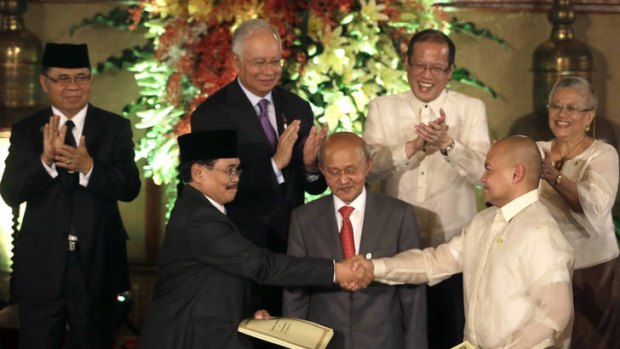 Muslim rebels and the Philippine government overcame decades of bitter hostilities and took their first tentative step toward ending one of Asia's longest-running insurgencies with the ceremonial signing of a preliminary peace pact that both sides said presented both a hope and a challenge.