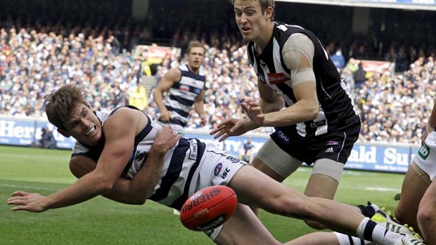 Going down swinging: Geelong's Tom Hawkins tries to tap the ball back into play.