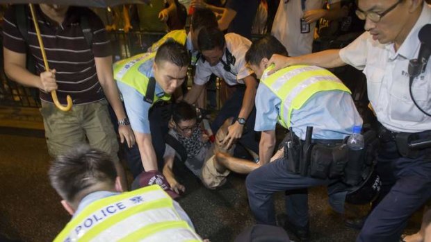 Police officers move a protester at Hong Kong's Mongkok district.