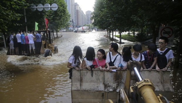 Residents use an excavator as they make their way to work in Wuhan.
