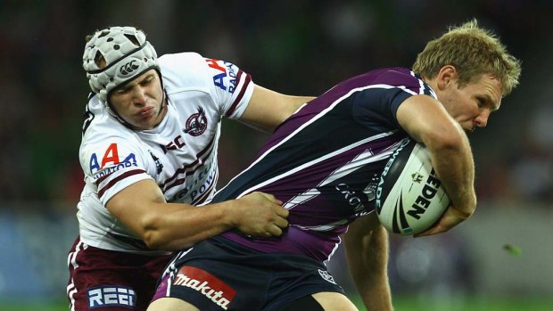 Todd Lowrie of the Storm is tackled by Jamie Buhrer of the Sea Eagles.