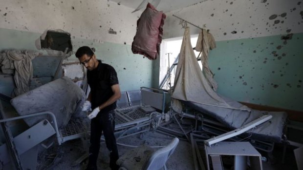 A Palestinian employee inspects damages at the al-Aqsa hospital in which five people died.