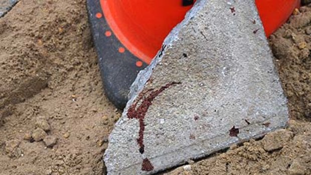 A blood-spattered block of concrete lies at the scene of the brawl.