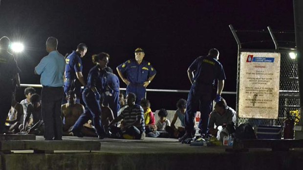 Customs officers and rescue personnel watch over survivors of the vessel that capsized on Tuesday.