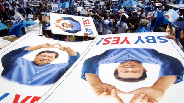 Supporters hold banners of Indonesian President Susilo Bambang Yudhoyono of the Democratic Party during an election campaign in Denpasar on the resort island of Bali.
