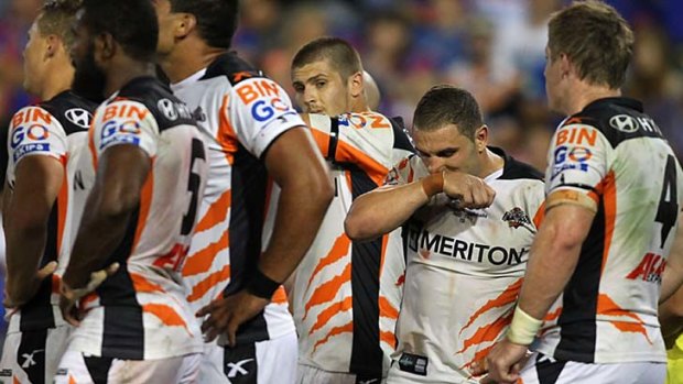 Poor start: dejected Wests Tigers players during the round-one game against Newcastle Knights.