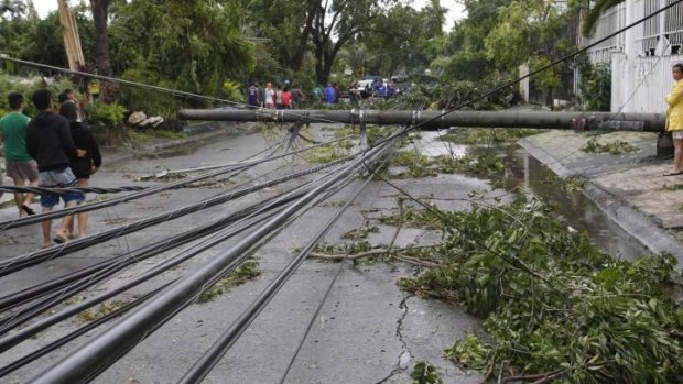 Electric cables lie on a road after its pole fell in Paranaque, Manila.