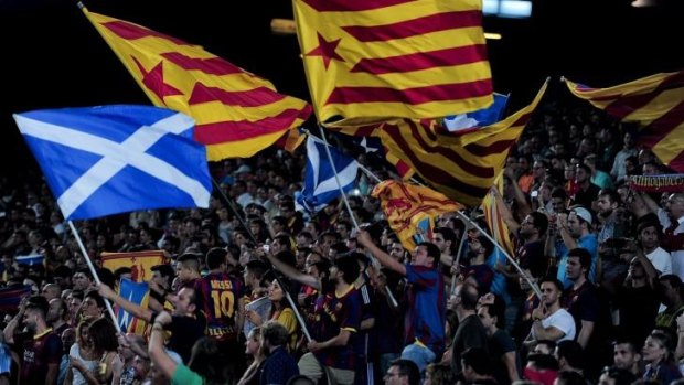 Like minds: Barcelona FC supporters wave Catalan and Scottish flags.
