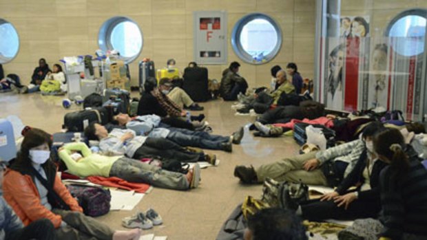Stranded by the curfew, and prevented from entering Cairo, passengers are forced to sleep at Cairo Airport.