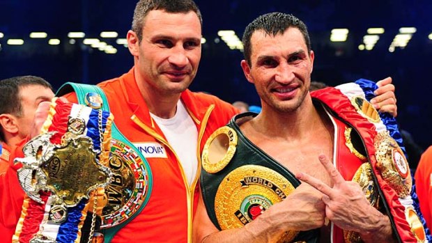 Wladimir Klitschko celebrates with his brother Vitali (L) after unifying the world heavyweight title.