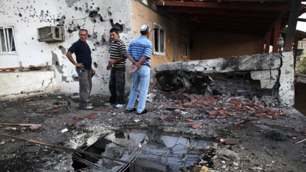 Israelis  inspect the damage to a house that was hit by a rocket fired by Palestinian militants.