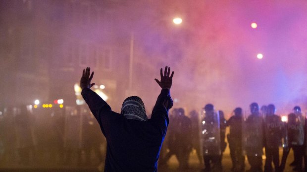 A protestor faces police enforcing a curfew in Baltimore on Tuesday.