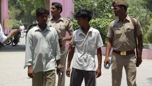 Suspects: Indian policemen escort two men accused of gang raping the two girls.